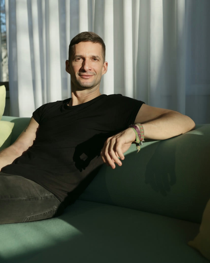 Marc Bernath entspannt auf einem grünen Sofa im Sonnenlicht